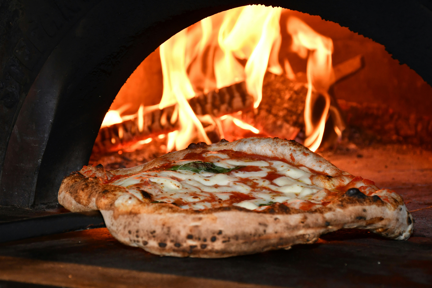Heißer Pizzastein im Ofen mit Ofenhandschuhen